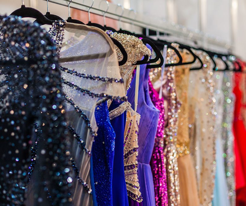 A lot of shiny evening gowns hang in the store